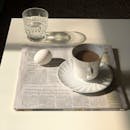 Cup of Coffee on Top of Newspaper