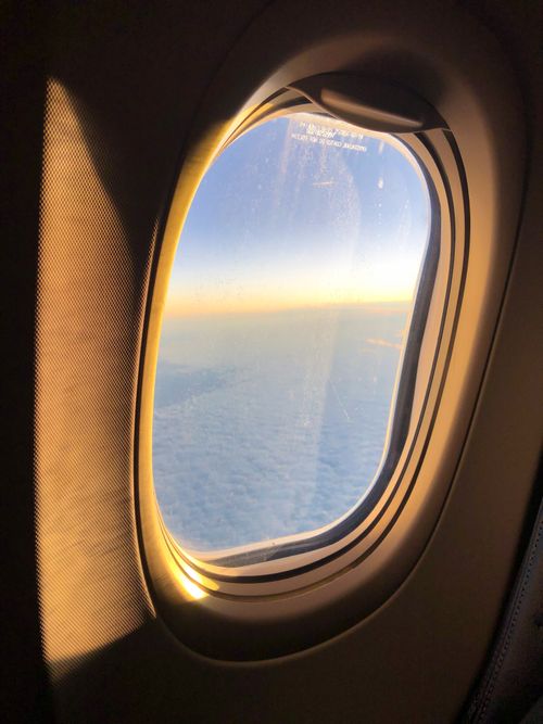Free Scenery from airplane window on white fluffy clouds in early evening during flight Stock Photo