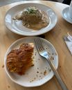 From above of plates of delicious puff pastry pie and fillet with mushroom sauce served on wooden table in restaurant