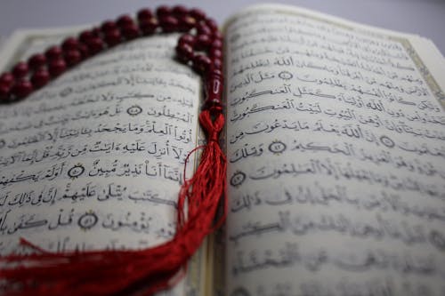 A Red Prayer Beads on Quran in Close-up Shot
