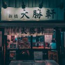 People in a Restaurant with Signage Illuminated at Night