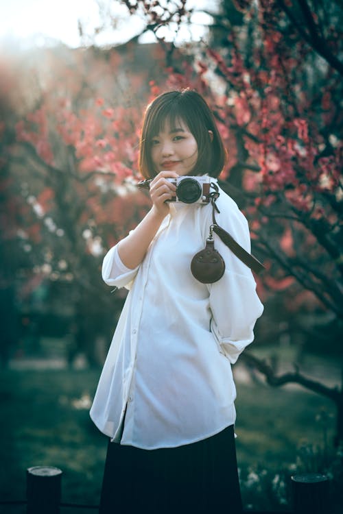 Beautiful Woman in a White Long Sleeve Shirt Holding a Camera