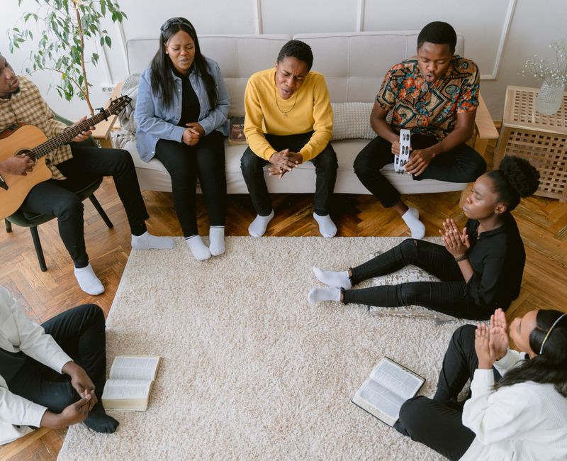Group of individuals engaging in Bible study and prayer