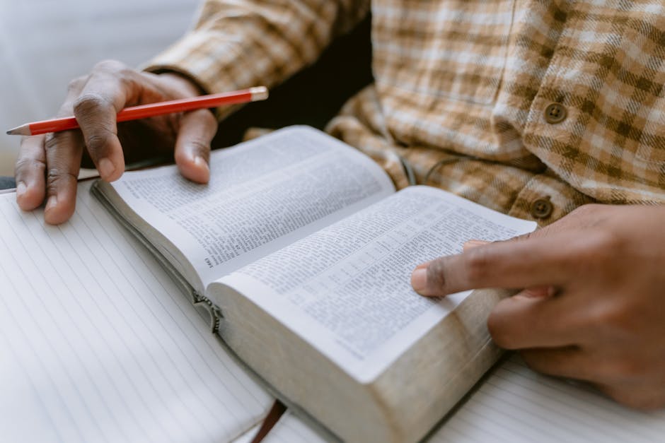 person journaling with a Bible open next to them - personal and spiritual development person journaling with a Bible open next to them - personal and spiritual development