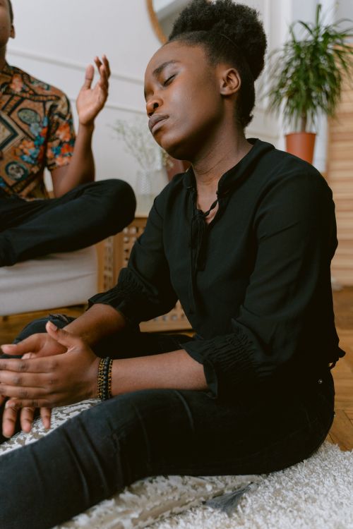 Calm black woman meditating with closed eyes at home · Free Stock Photo