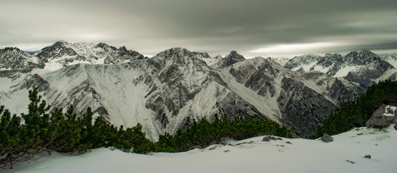 白雪覆盖的山脉和阴云密布的天空令人叹为观止，展示了大自然的原始美景