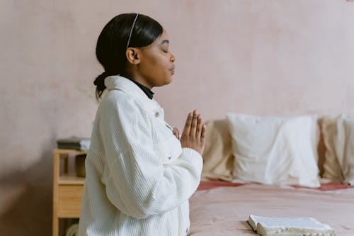 A Woman Praying Beside Her Bed