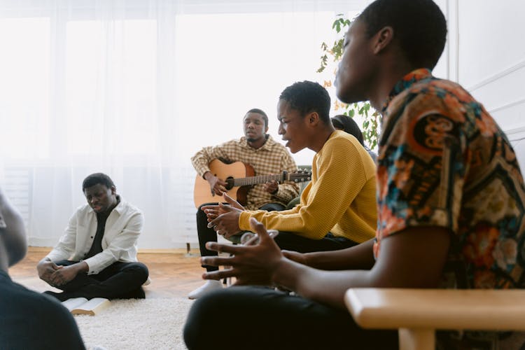 A Group Of People Singing In A Room