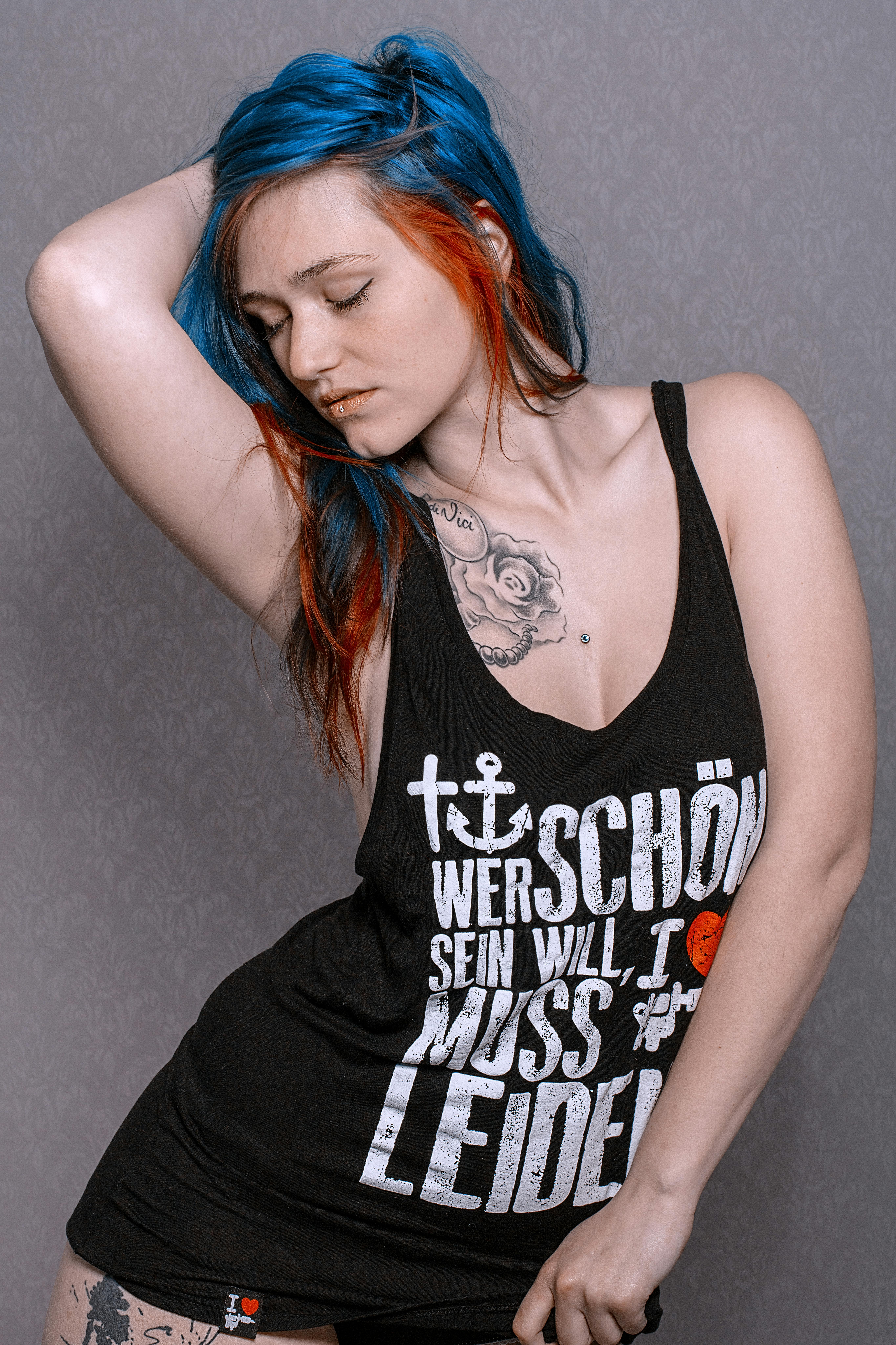 Portrait of a woman with blue hair striking a creative pose in Leipzig, Germany.