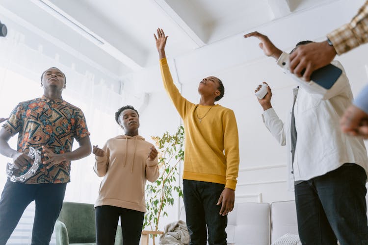 A Group Of People Singing In A Room