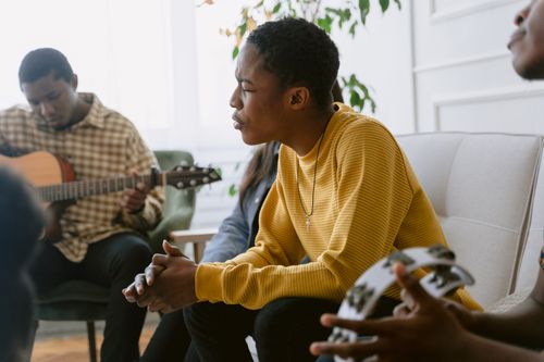 Free A man passionately sings while participating in a group music rehearsal indoors. Stock Photo