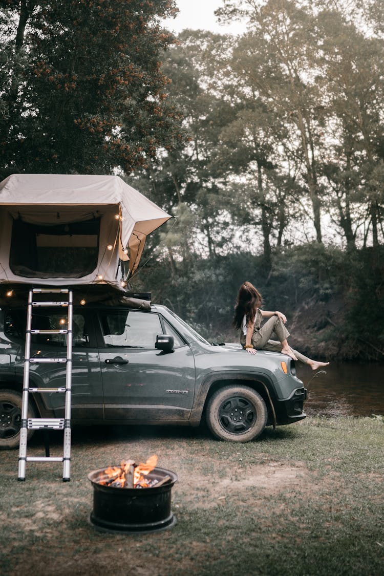 Woman Sitting On The Hood Of A Car