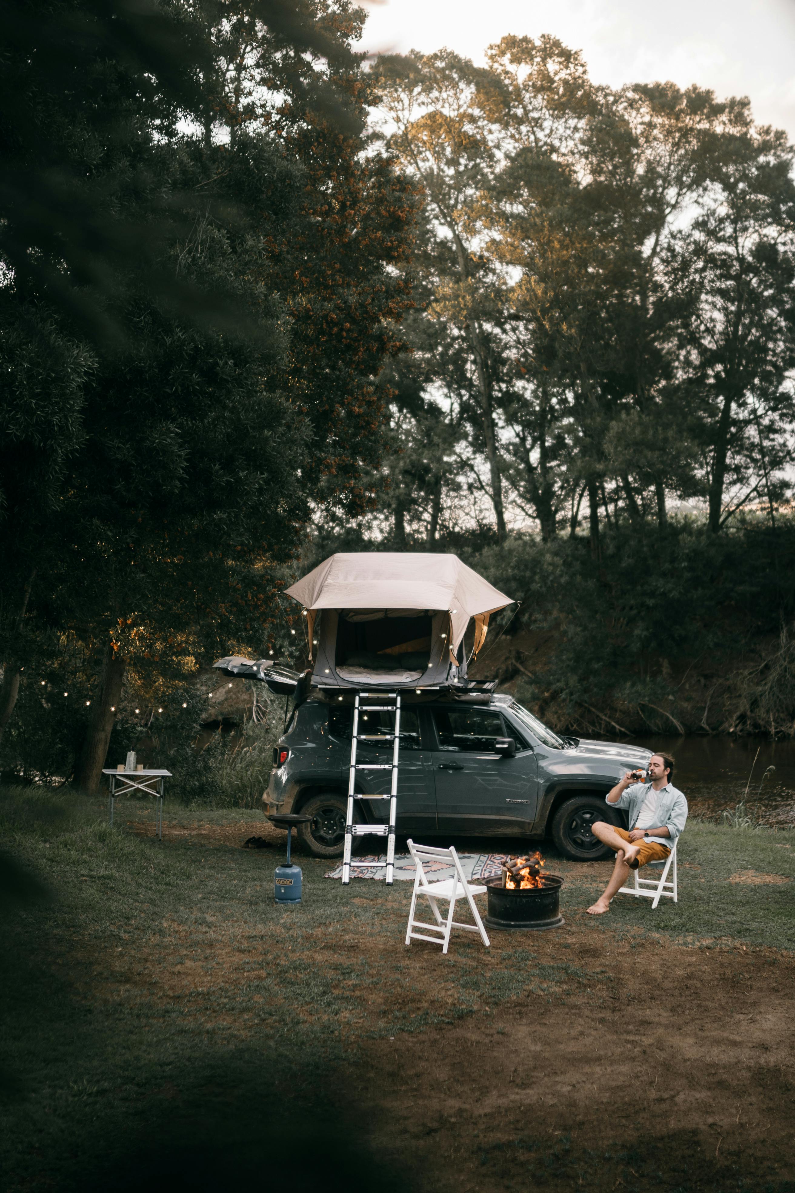 man sitting on a white chair near a car