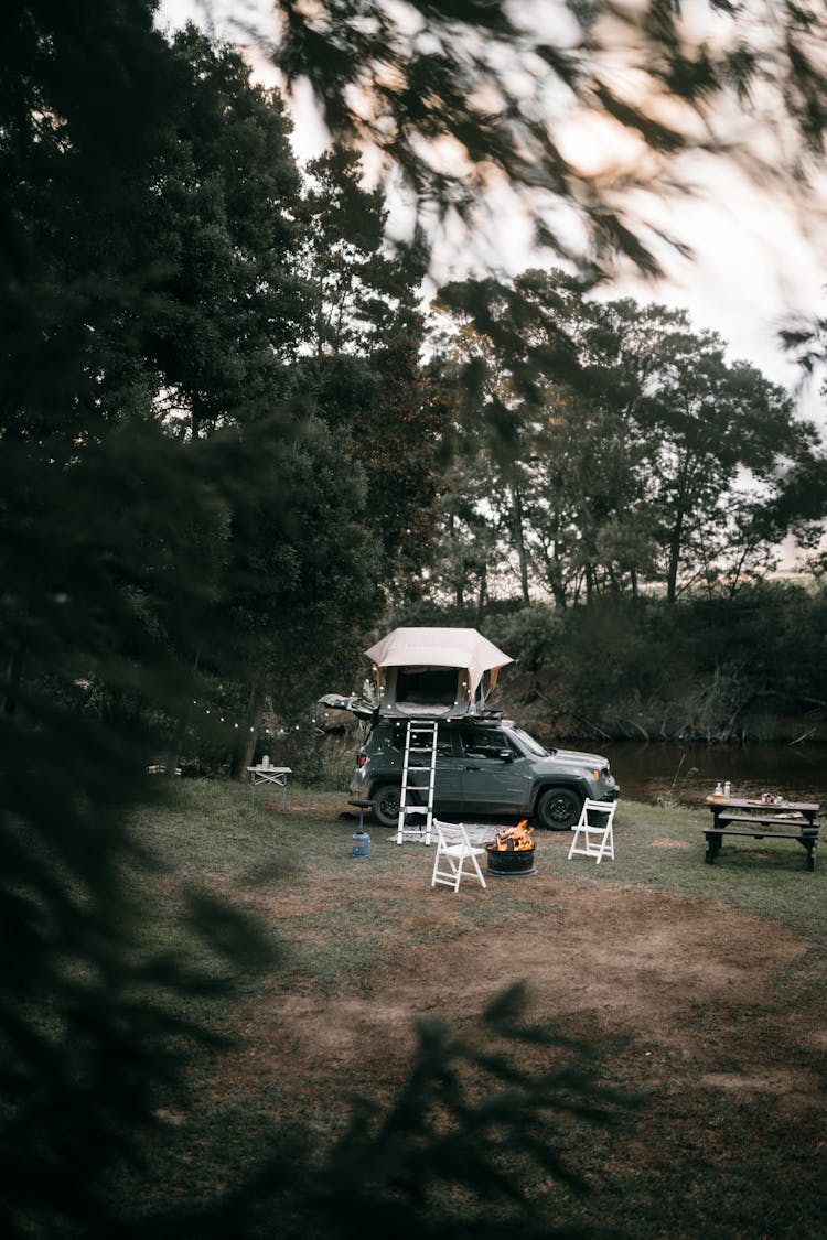 A Camping Site With A Car And A Tent