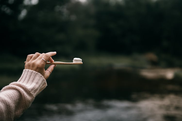 Photo Of A Person's Hand Holding A Toothbrush With Toothpaste