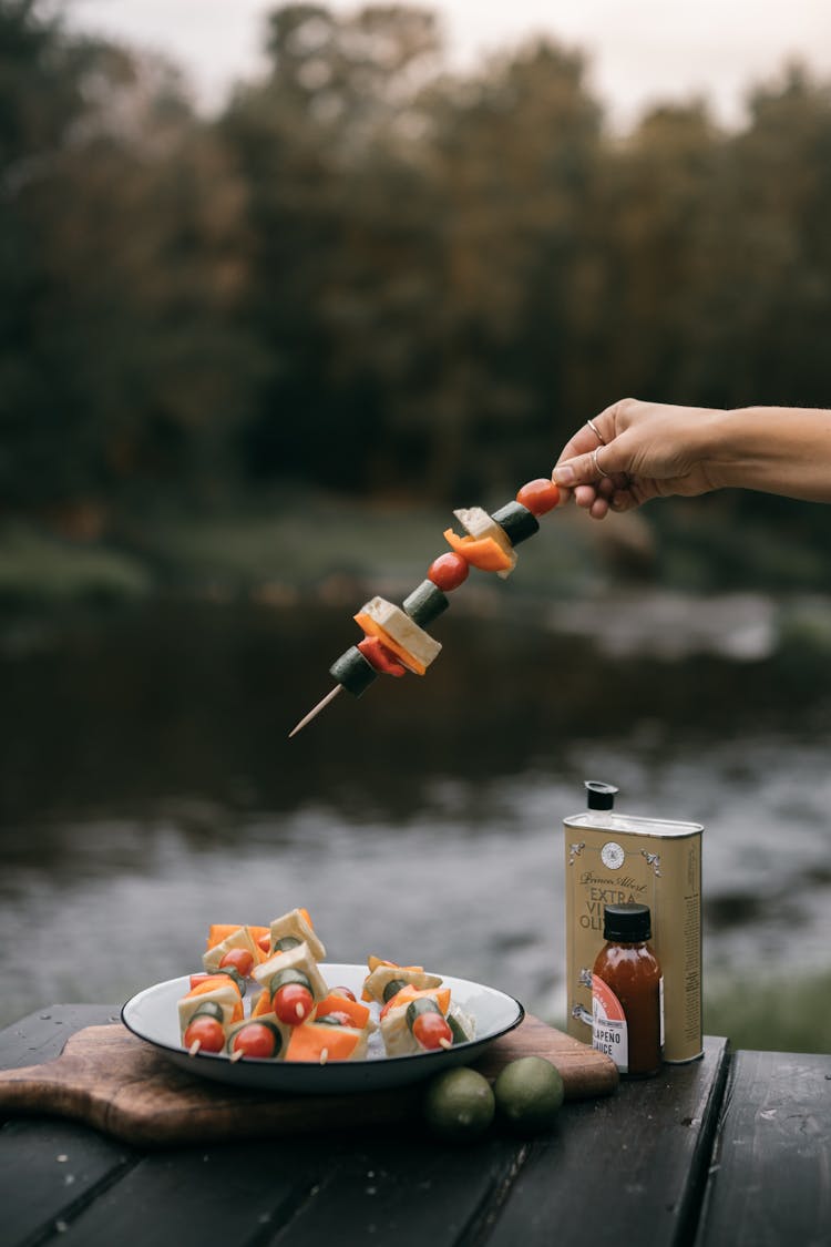 Photo Of A Person Holding A Skewer With Vegetables