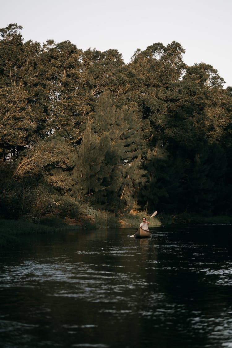 A Man Kayaking On A Lake