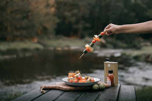 Free A Person Getting a Skewer with Vegetables Stock Photo