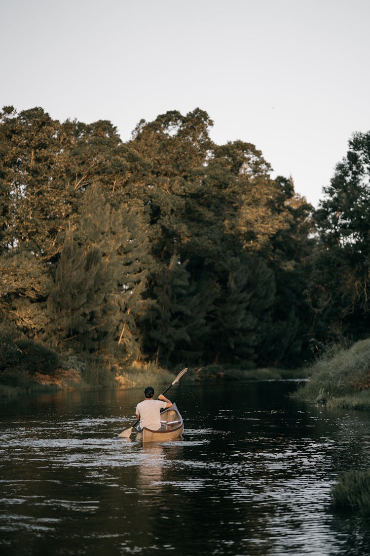 A Man Kayaking On A Lake