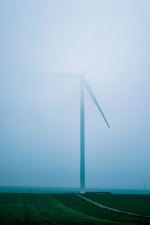 Free High modern windmill as alternative renewable power generation placed in countryside in foggy day Stock Photo