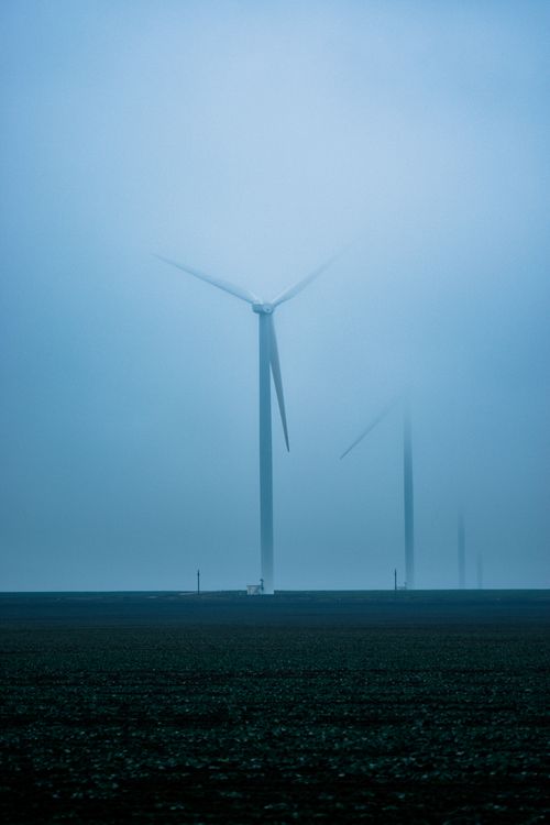 Free Many modern high windmills placed on grassy field in countryside in cloudy day Stock Photo