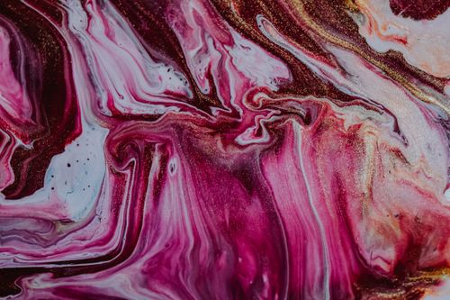 Free From above of abstract backdrop with wavy pink and brown paint fluids mixing with golden glitters Stock Photo