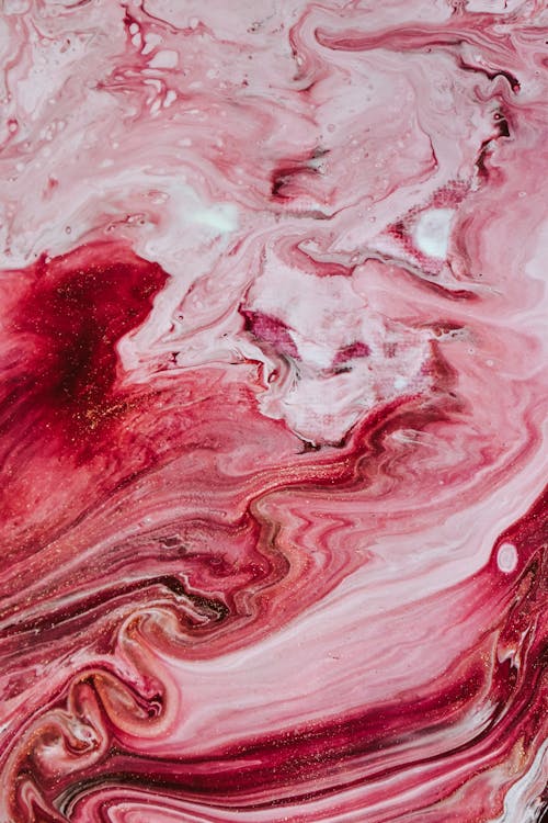 Top view of colorful abstract backdrop representing artwork with curved red and pink dye streams