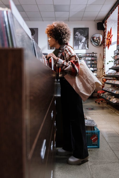 Woman Checking Vinyl Records at the Store