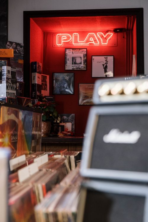 Free Explore a retro vinyl record store featuring a glowing neon 'Play' sign and vintage albums. Stock Photo