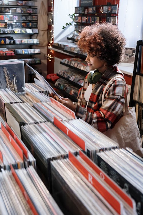 Woman in Red and White Plaid Shirt Checking the Vinyl Record