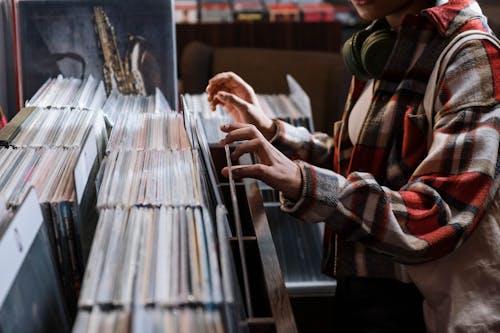 Person in Red and White Plaid Shirt Checking the Vinyl Record