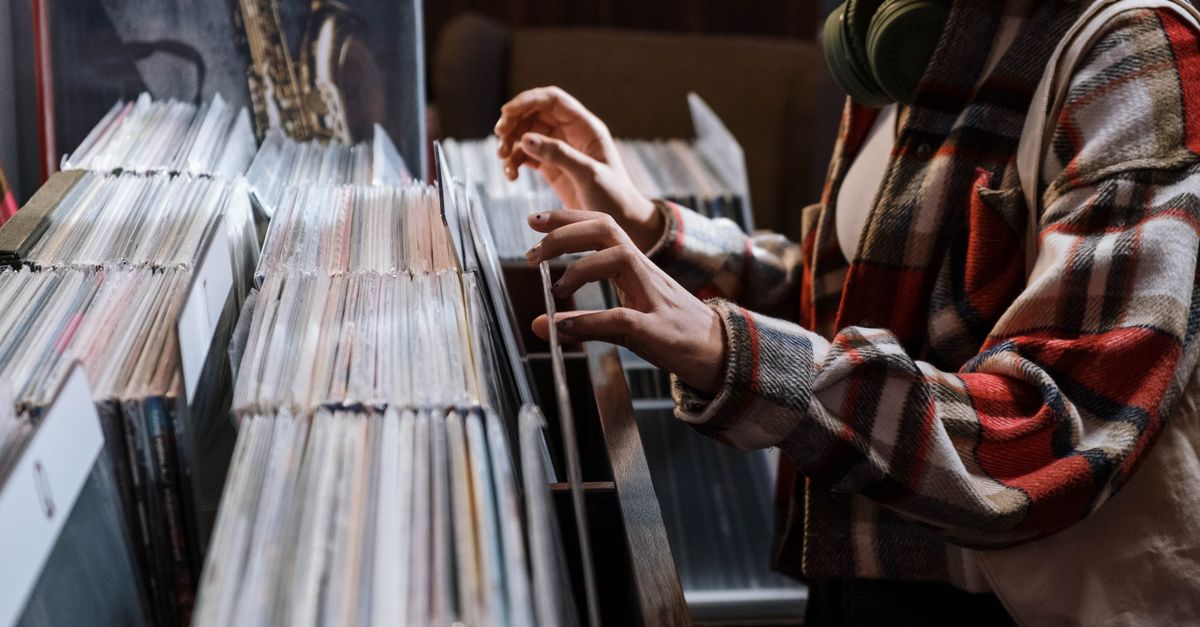 Gen Z teenager browsing vinyl records in a record store