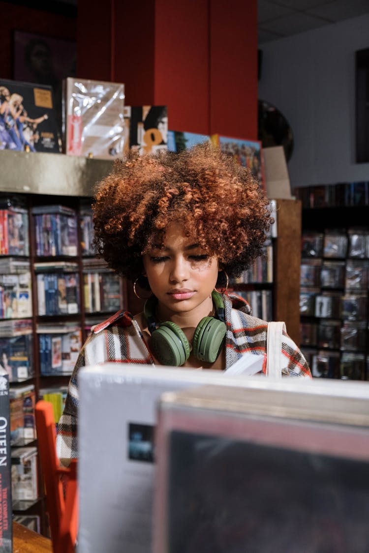 Woman In Red And White Plaid Shirt Checking The Records