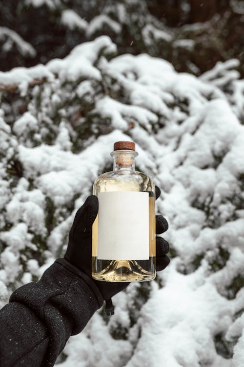 A Person Holding a Glass Bottle 