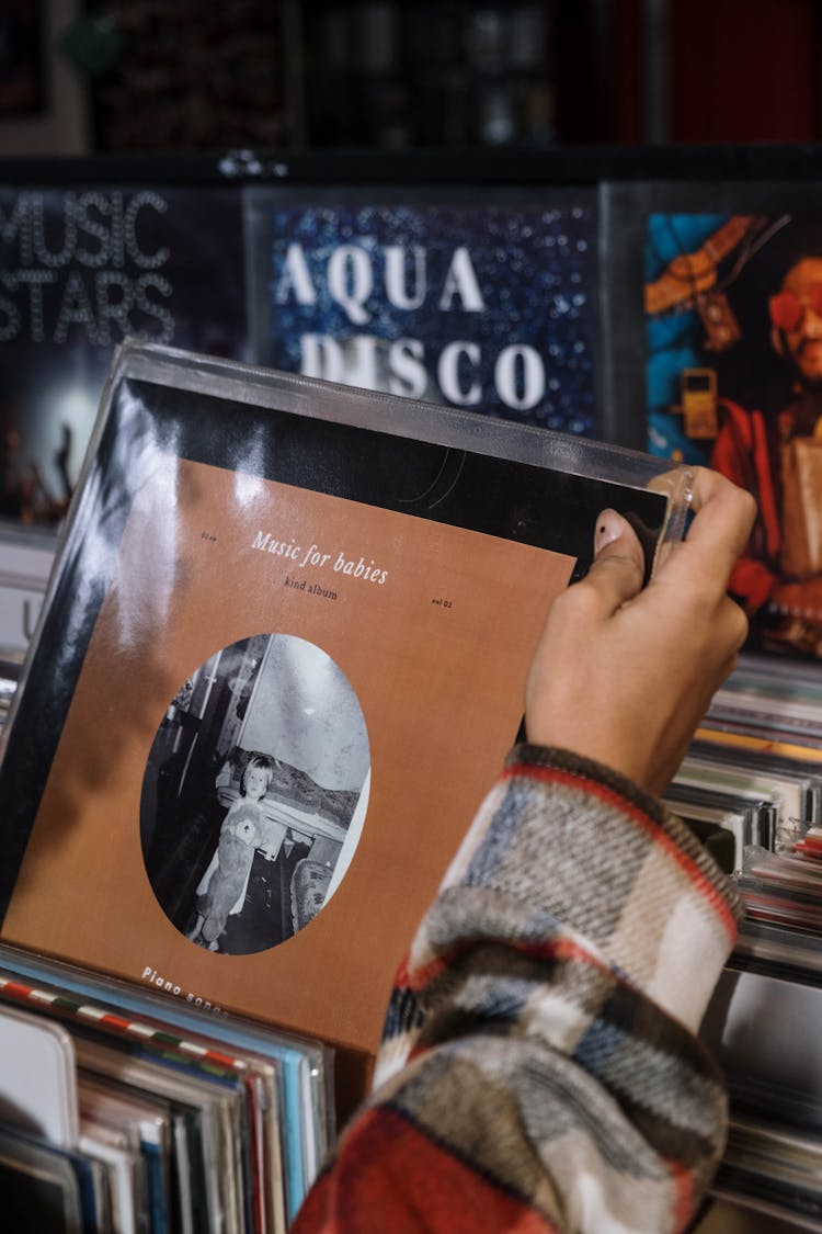 Photo Of A Person's Hand Holding A Vinyl Record