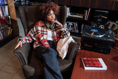 Woman in a Plaid Shirt Sitting Near a Gramophone