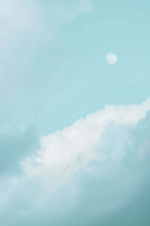 Free Fluffy clouds near moon on blue sky Stock Photo