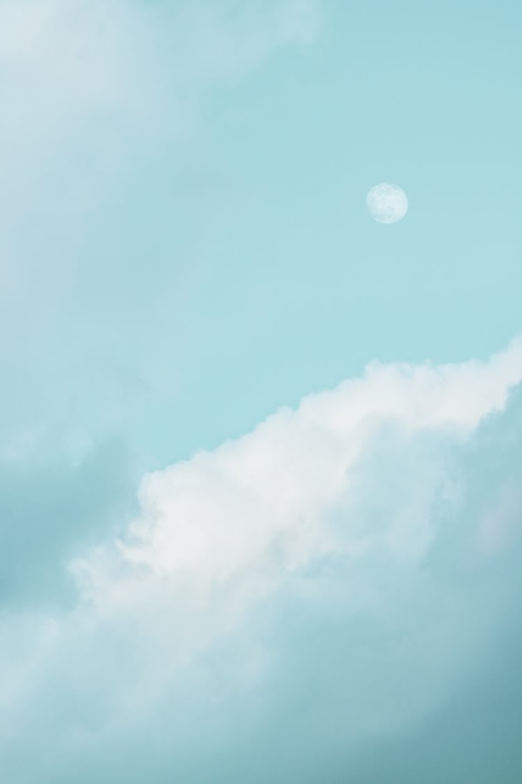 Fluffy Clouds Near Moon On Blue Sky