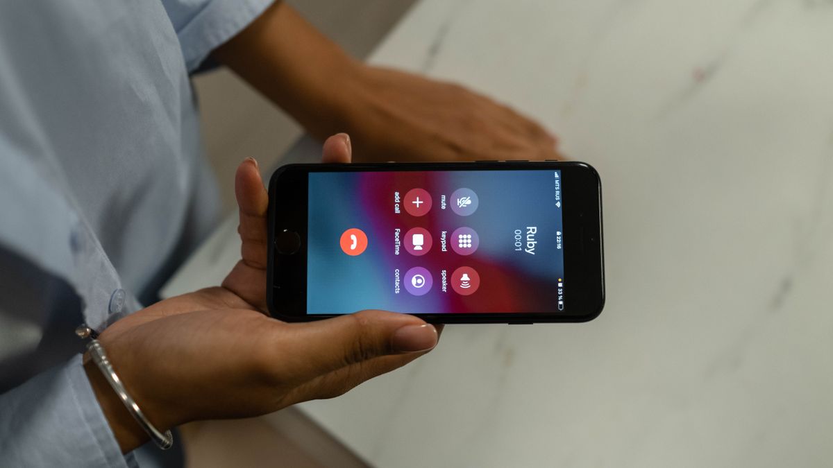 通話中のスマートフォン画面を持つ手元のイメージ
