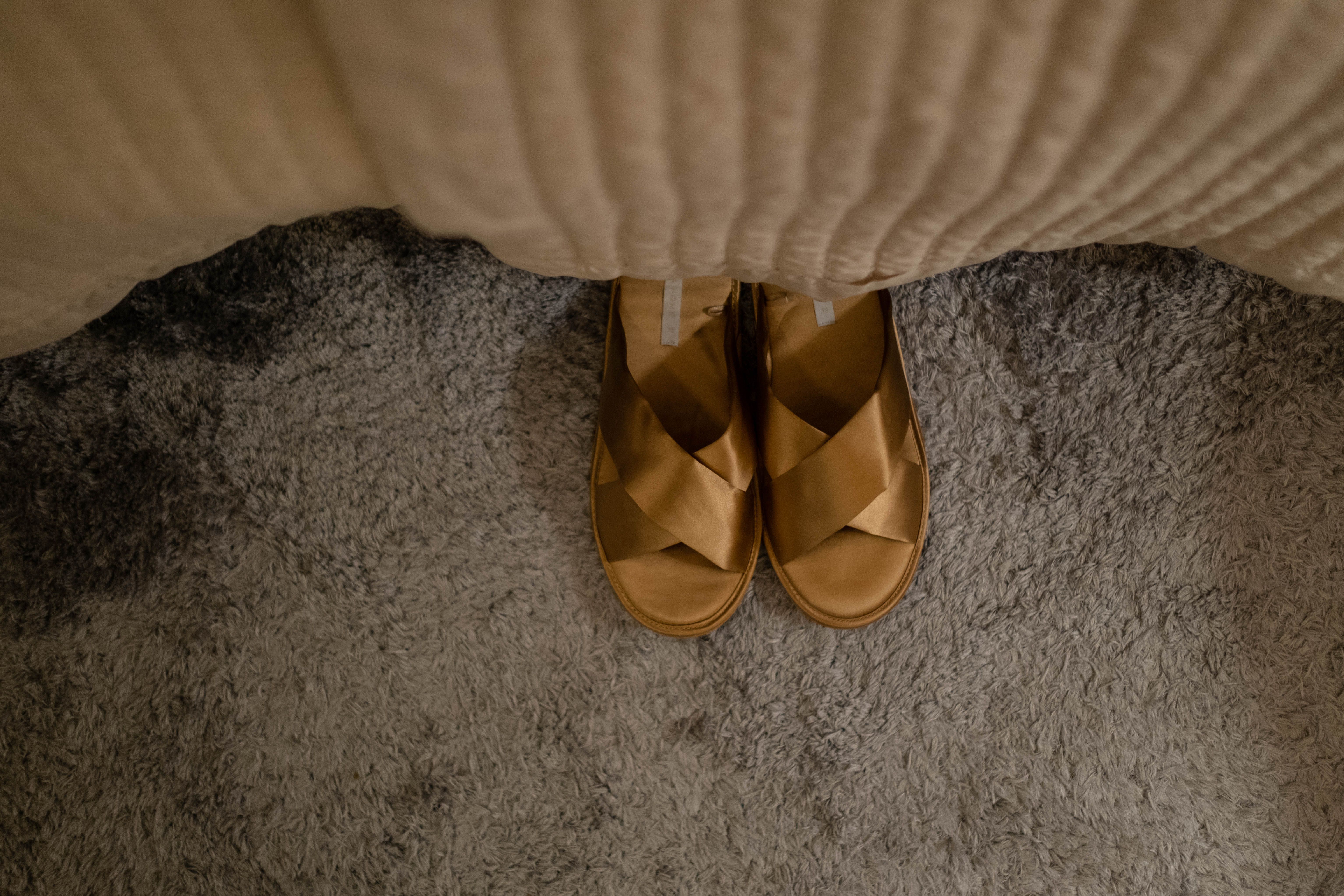 A pair of cozy sandals on a textured carpet, creating a warm indoor vibe.