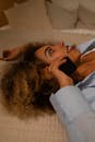 Woman Talking on the Phone while Lying on a Bed