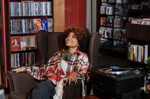 A Woman with Curly Hair Listening to Music