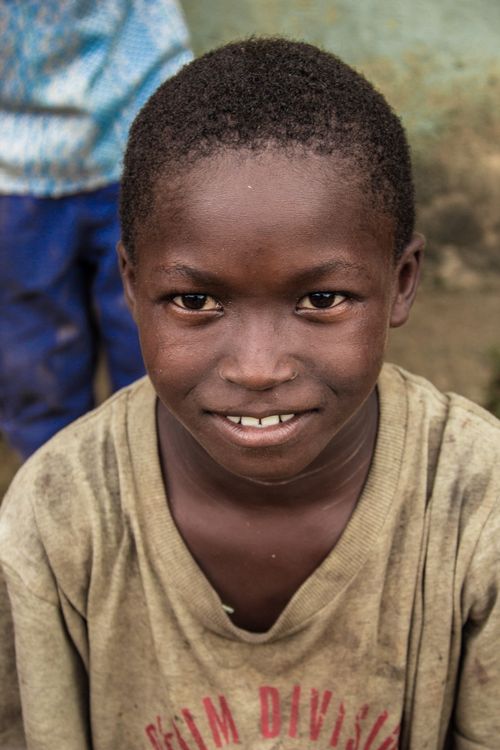 Free A joyful African child in Accra, Ghana, with a warm smile wearing a casual shirt outdoors. Stock Photo