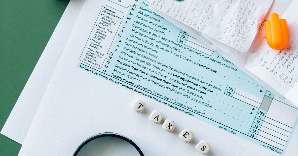 Photo by Nataliya Vaitkevich Top view of tax forms, calculator, coins, and office supplies on a green desk.