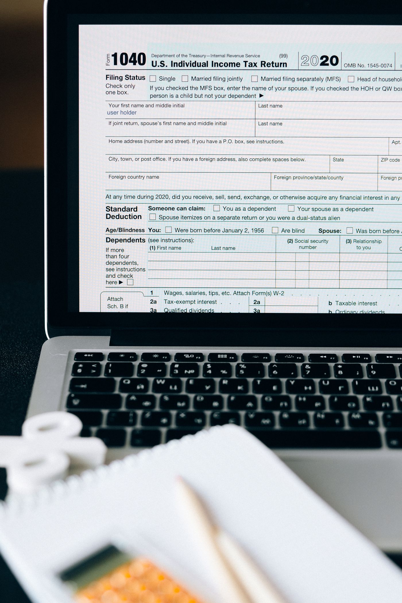 Income tax calculation using laptop calculator and financial documents