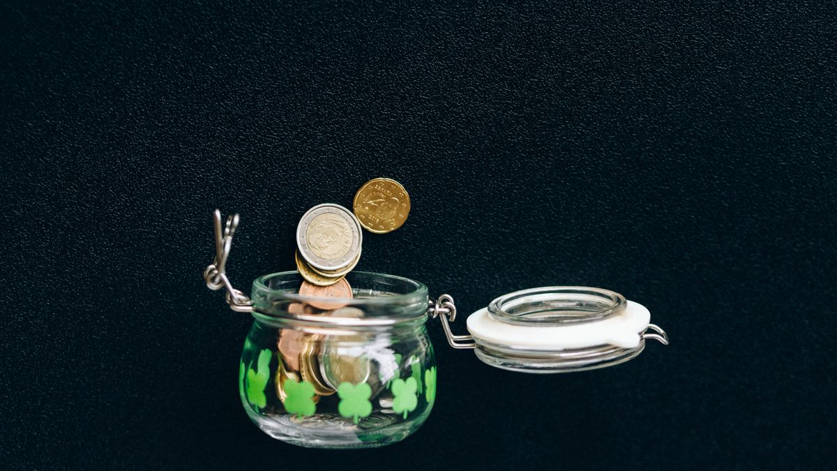 Pieces de monnaie et tirelire symbolisant le cout et les economies sur le permis de conduire