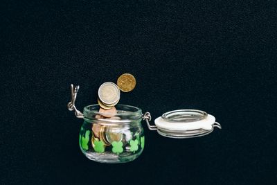 Coins dropping into a glass savings jar on a dark background — photo by Nataliya Vaitkevich on Pexels