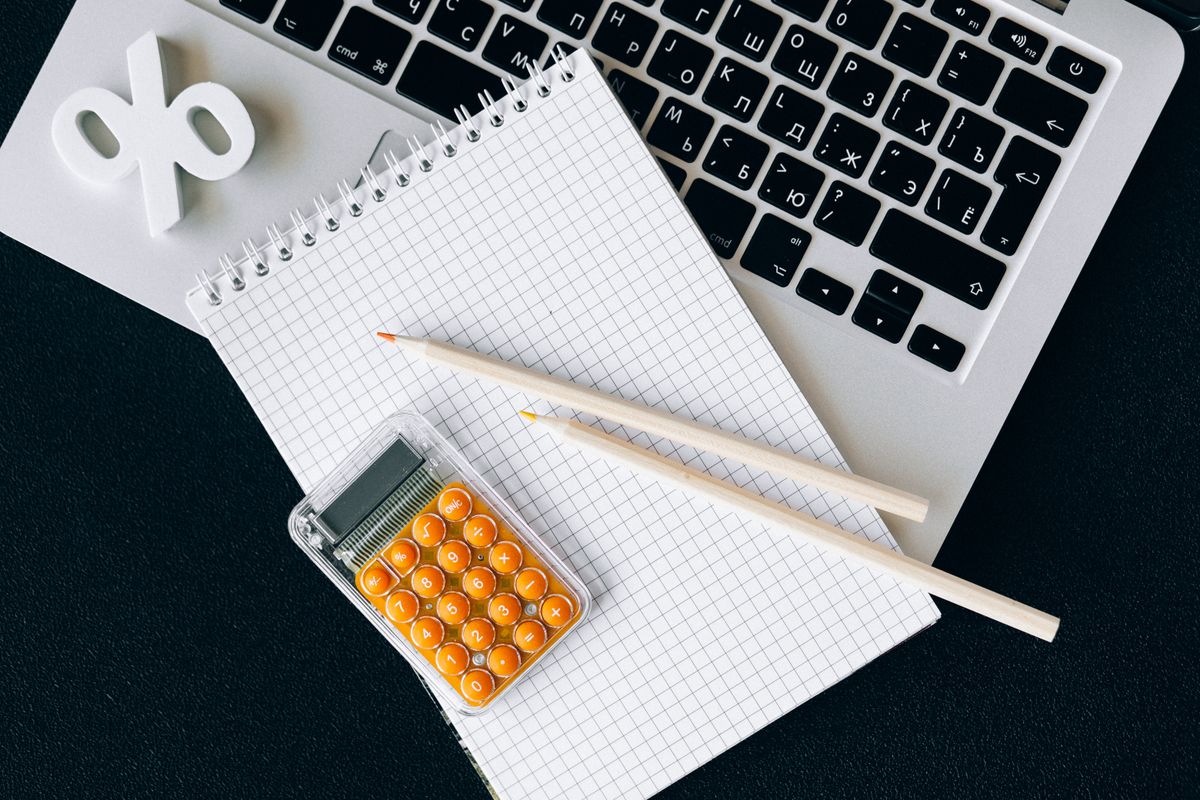 A calculator and notebook on a desk