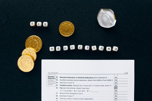 Free Image of tax deductions concept with coins and tax form on black background. Stock Photo
