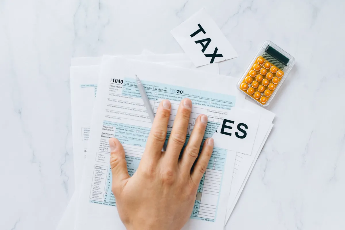 Tax forms, receipts and a calculator arranged on a desk during return preparation